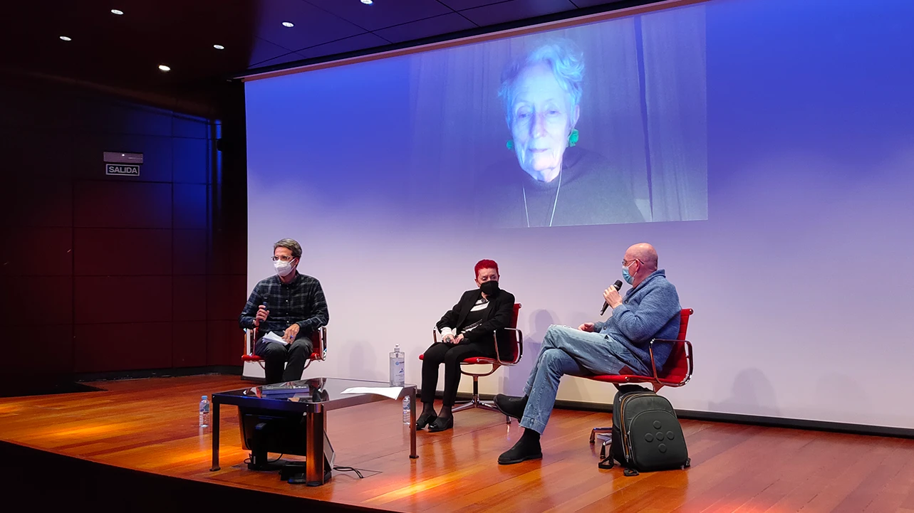 Encuentro con Concha Jerez, 2021. En la imagen (de izquierda a derecha): Chema González, Concha Jerez y Fernando Castro Flórez. Mieke Bal en pantalla. Fotografía: Celia Maldonado