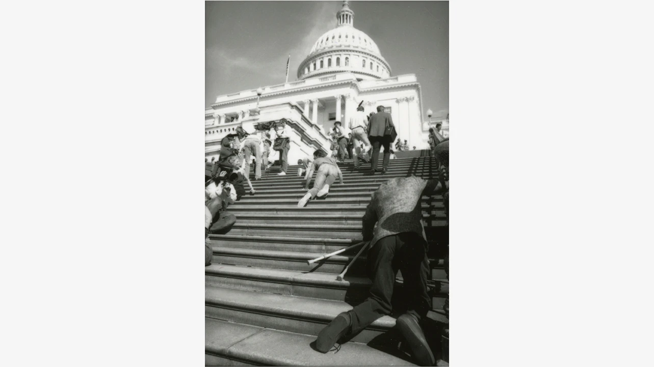 Un grupo de activistas discapacitados dejan sus sillas de ruedas y suben arrastrándose por las escaleras del Capitolio, en Washington D.C., el 2 de marzo de 1990, con el fin de presionar a los legisladores para que firmasen la Americans with Disabilities