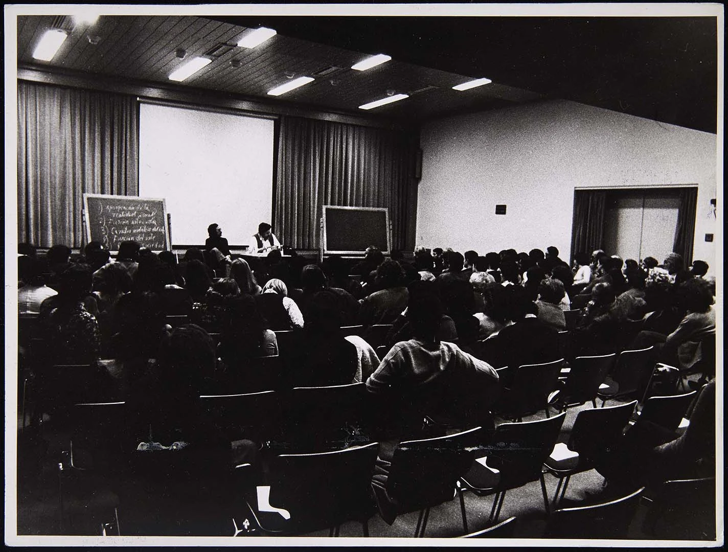 Fotografía de Simón Marchán Fiz con Wolf Vostell en el ciclo Nuevos comportamientos artísticos, 1974. Archivo Marchán/Quevedo. Biblioteca y Centro de Documentación del Museo Reina Sofía