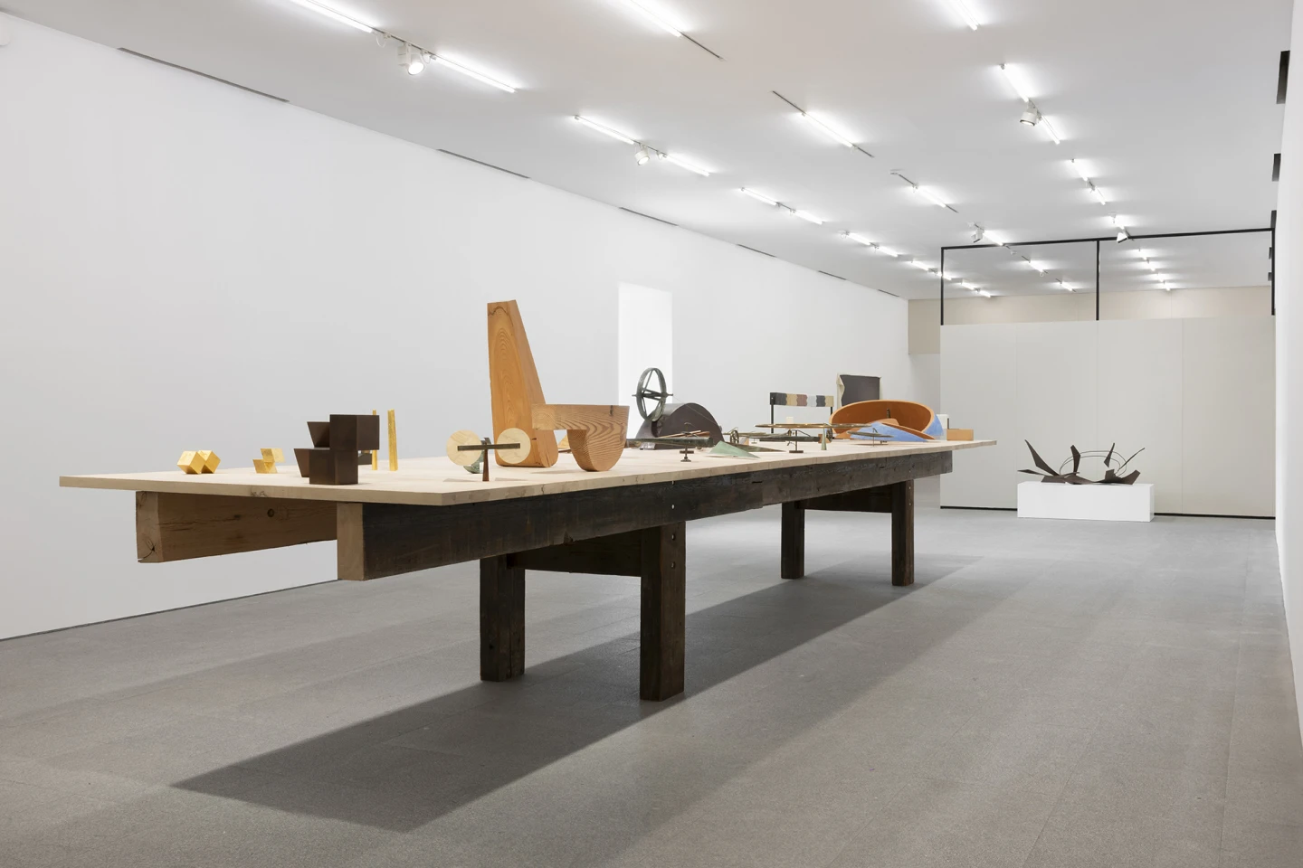 Vista de Sala 11 «Estructuralismo escultórico en los años setenta». En primer plano: Juan Navarro Baldeweg, La mesa, 1974-2005. Museo Reina Sofía. © Juan Navarro Baldeweg, VEGAP, Madrid, 2026. Al fondo: Anthony Caro, Table Piece CCXXXII. The Dance [Pieza de mesa CCXXXII. La danza], 1975. Museo Reina Sofía. © The State of Anthony Caro/ Bradford Sculptures Ltd, 2015. Fotografía: Roberto Ruiz 