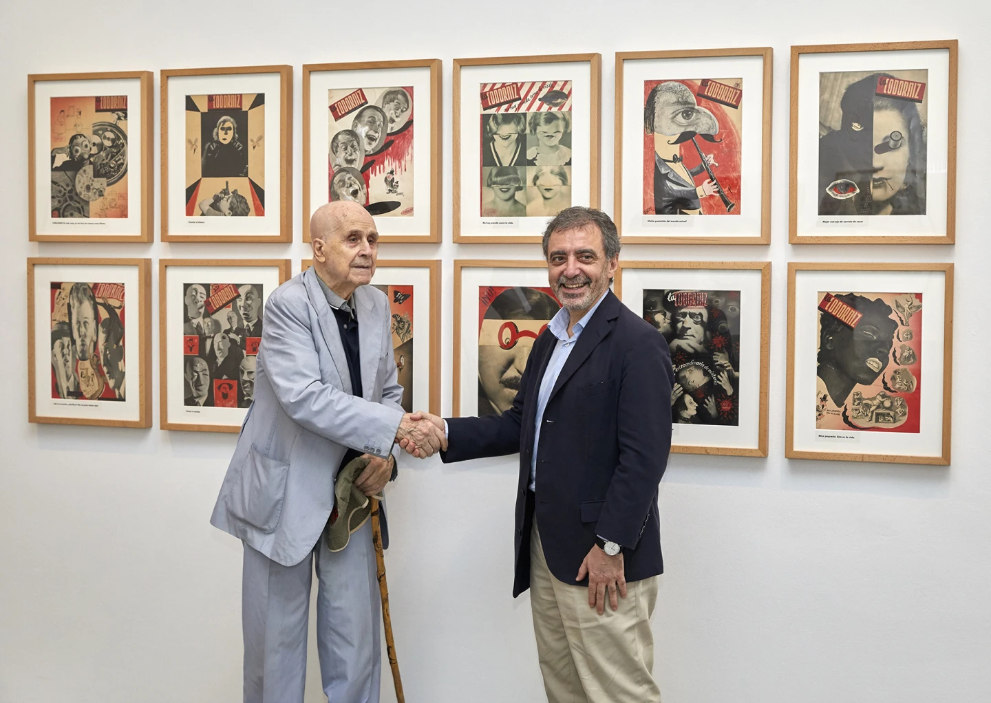 Enrique Herreros y Manuel Borja-Villel, tras las firma del acuerdo, delante de unas portadas de La Codorniz