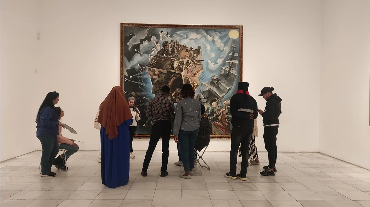 Un grupo de visitantes frente a la obra Un mundo de Ángeles Santos