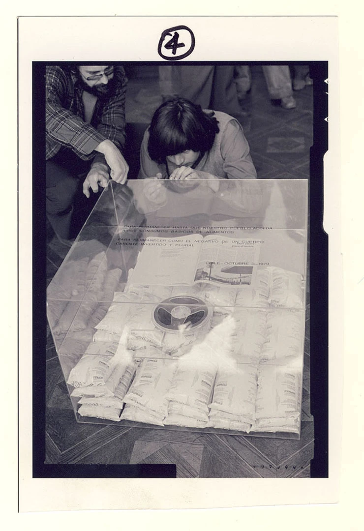 Juan Castillo terminando de pegar la tapa de la caja en la acción Para no morir de hambre en el arte, 1979. Archivos en uso