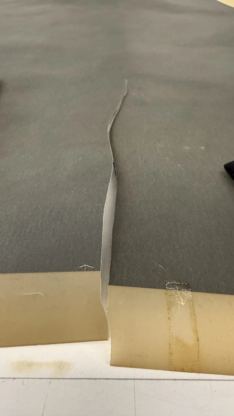 Restos de cinta adhesiva y deformación del soporte por la rotura del papel vegetal