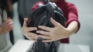 Persona ciega explorando una escultura durante la actividad