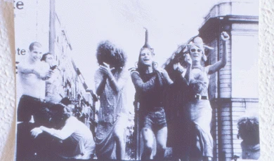 Una fotografía en blanco y negro de un grupo de personas bailando en el centro de una ciudad