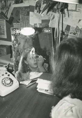 Autor desconocido, [Blanca Sánchez reflejada en un espejo pintándose los ojos], ca. 1975